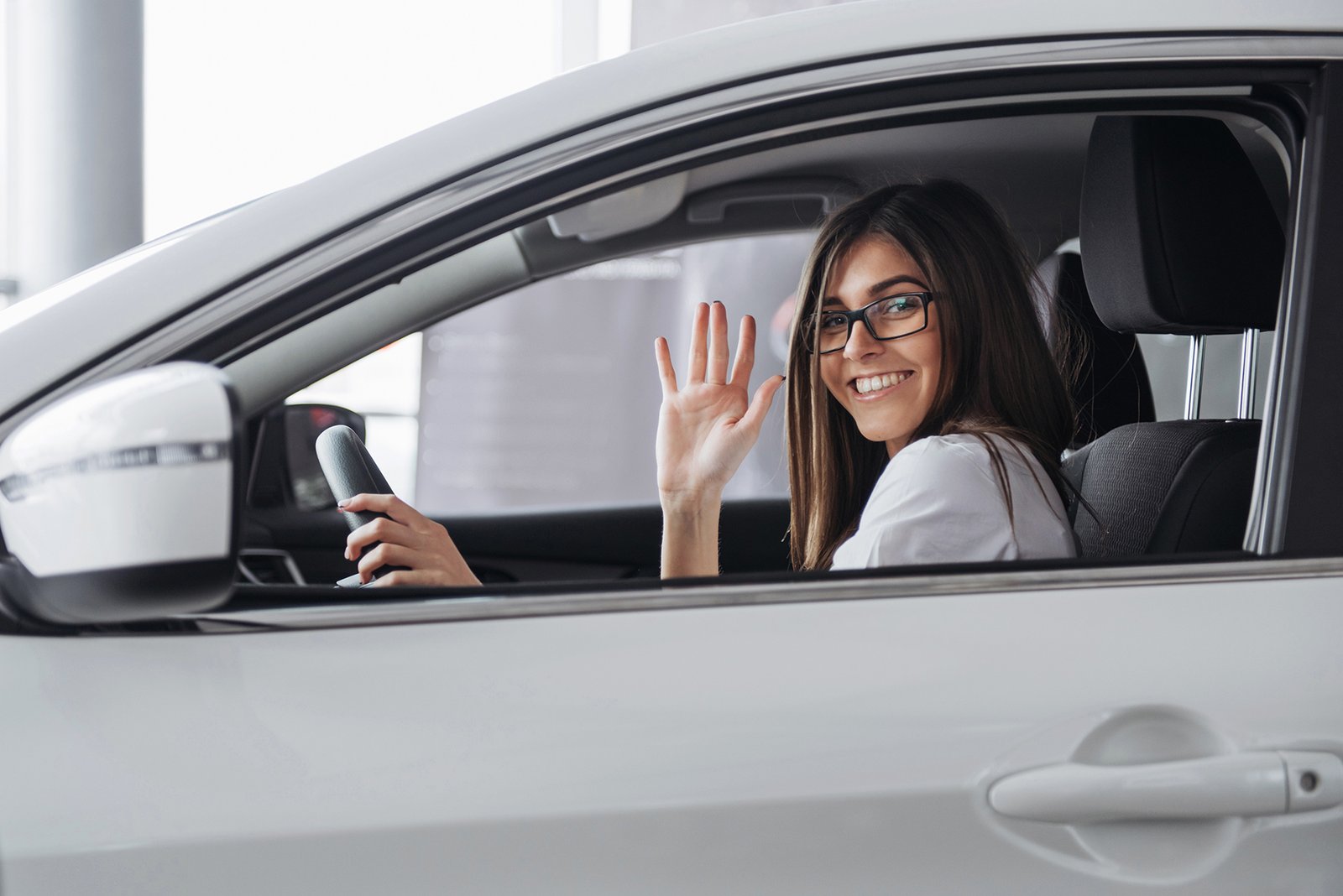 Pretty young woman driving new car. Mujer-con -licencia-de-conducir-guadalajara